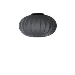Sort, oval lampe med ribbet tekstur og minimalistisk design, egnet til loft- eller vægmontering.